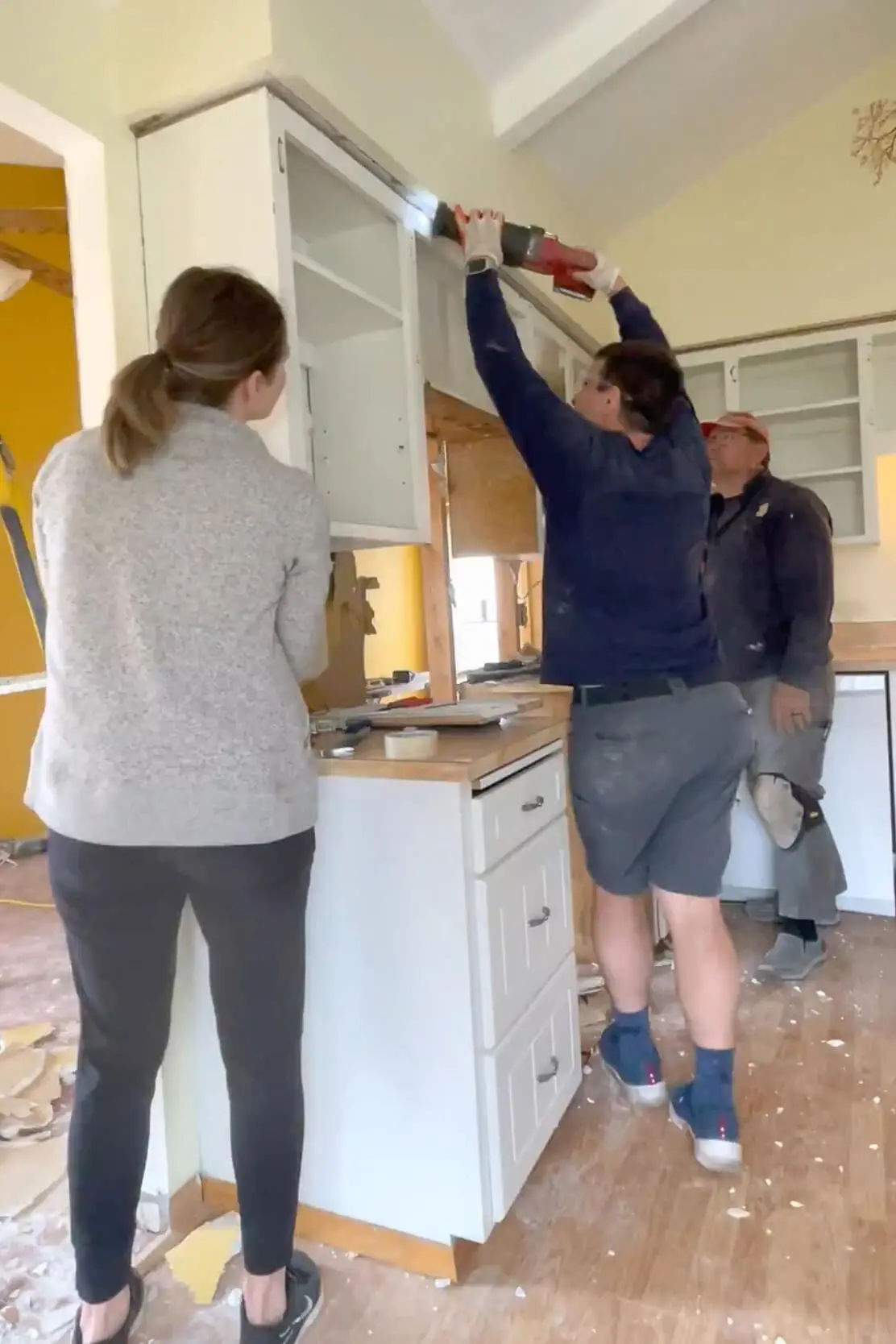 Removing old cabinets during DIY kitchen remodel.